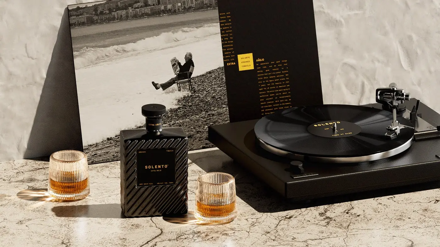 A sophisticated monochromatic bottle of Solento Organic Tequila Extra Añejo sits elegantly against a dark background, with embossed detailing and a velvet-textured finish, reflecting Studio Ethur Ethur's commitment to luxury design.