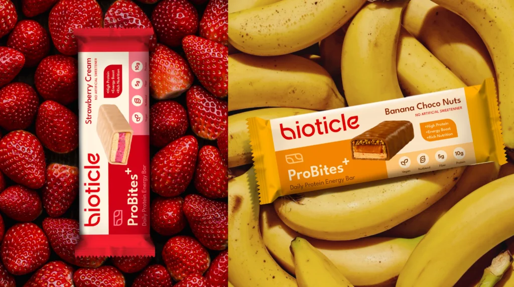 ProBites+ wrappers on ingredient backdrops, Strawberry Cream on strawberries and Banana Choco Nuts on bananas, flavor led branding and packaging design.